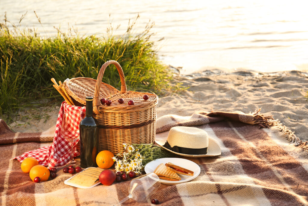 Košara za piknik za romantično večerjo na plaži ob reki