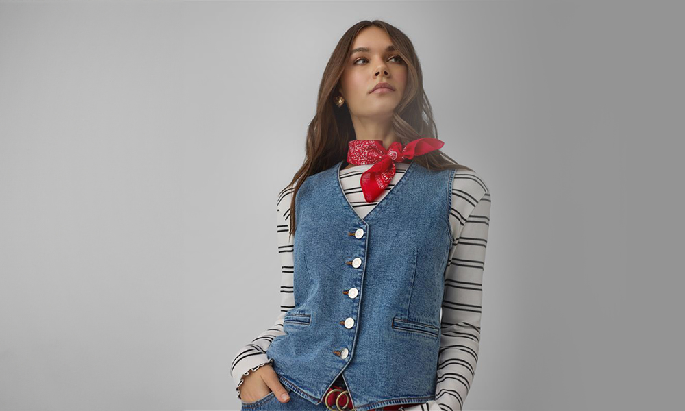 Ženska nosi modro traper jakno in rdečo bandano okoli vratu.